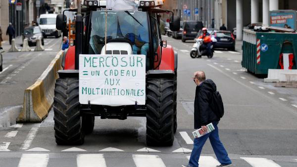 MERCOSUR= UN REGALO PARA LAS MULTINACIONALES se lee en un tractor de la protesta en Bruselas